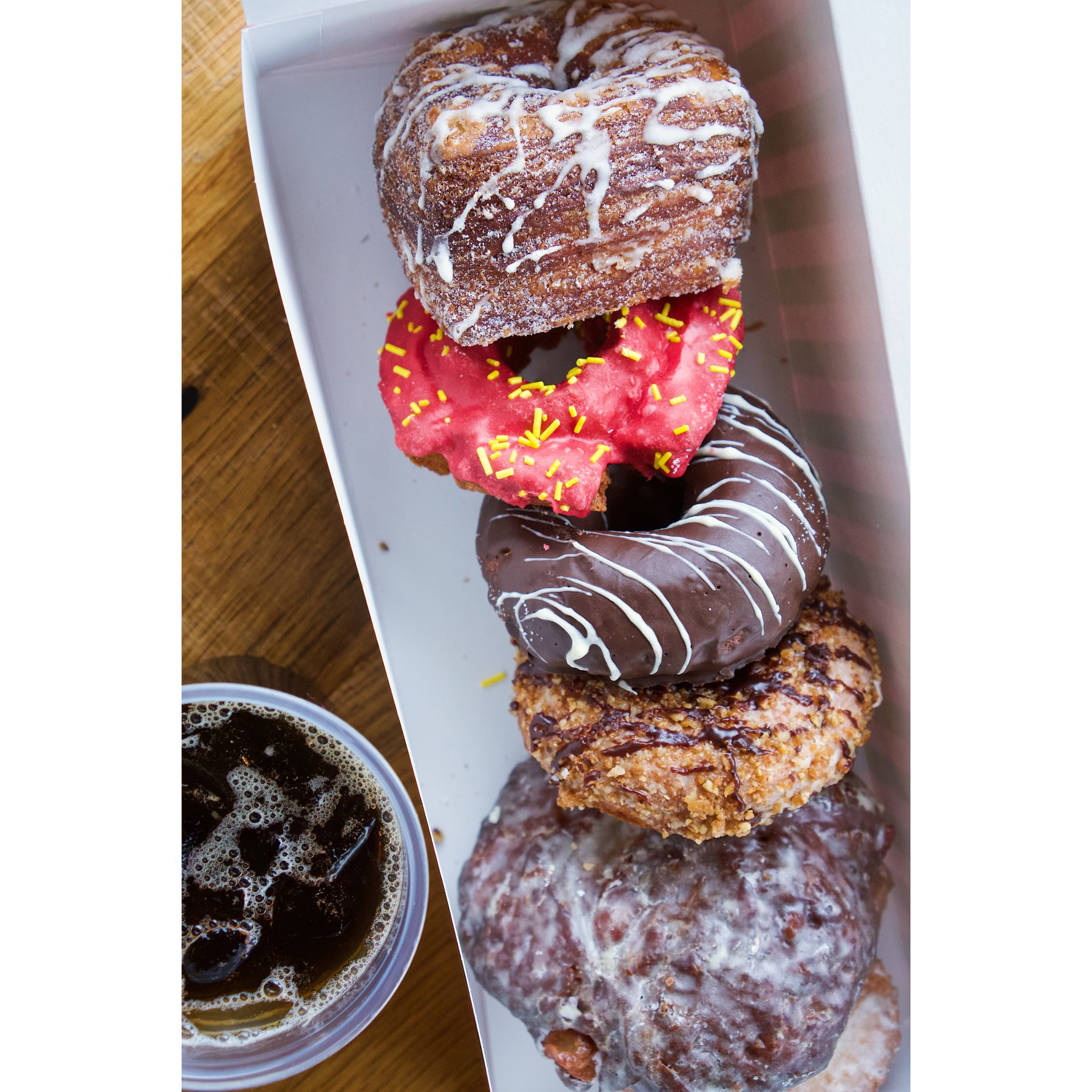 Stan's Donuts — Four donuts in tray with coffee cup overhead